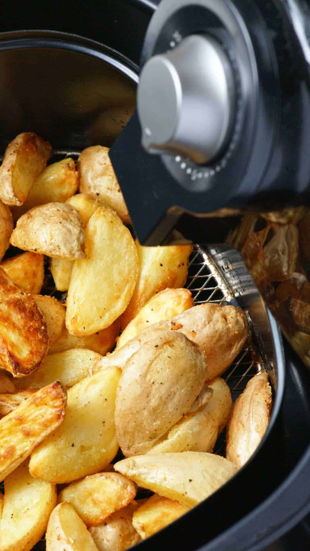 Goldbraune Kartoffelecken im Korb einer Heißluftfritteuse