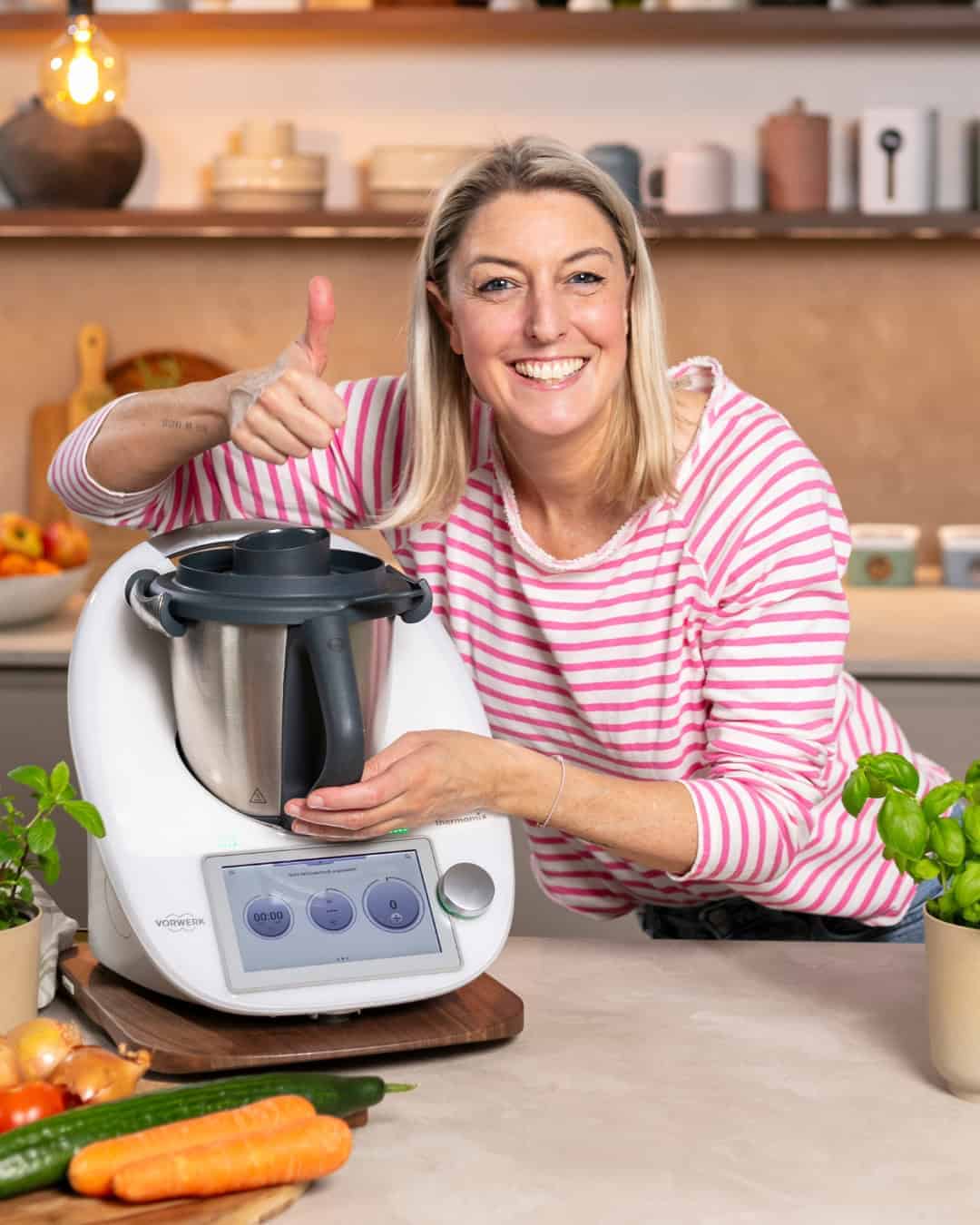 Desi von mein Zaubertopf steht neben ihrem Thermomx und zeigt einen Daumen nach oben